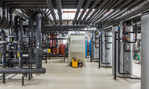 Ein Raum mit Rohren und Ventilen, der industrielle Elemente und technische Ausstattung zeigt.